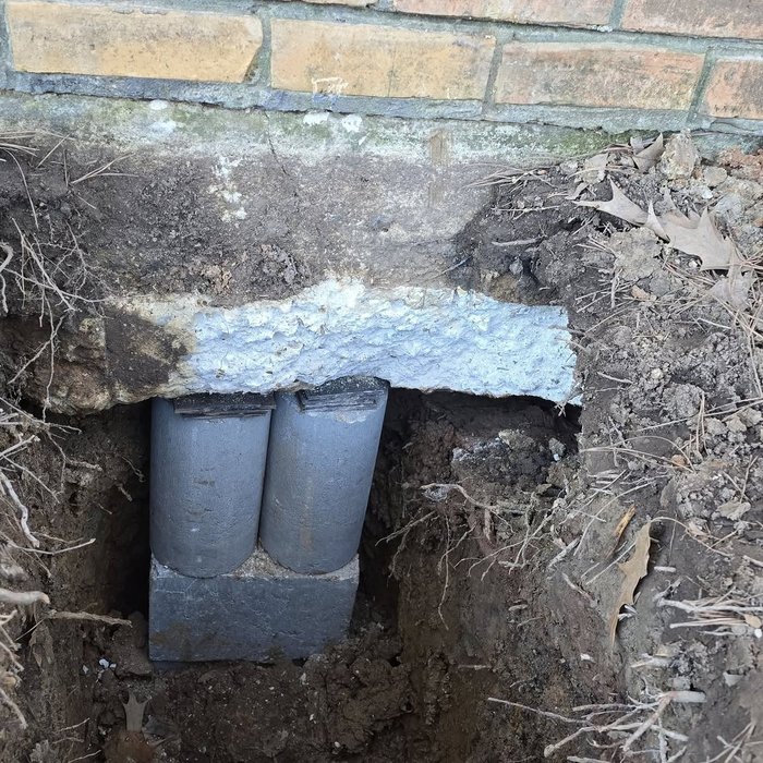 Concrete piers installed beneath brick foundation